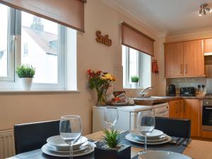 a kitchen with a table with wine glasses on it at Filey Central One - Uk31706 in Filey