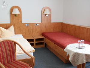 Zimmer mit einem Bett und einem Tisch mit einem Stuhl in der Unterkunft Hotel Garni Melchendorf in Erfurt