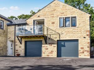 a house with two garage doors and a balcony at Kinneret Apartment in Silsden