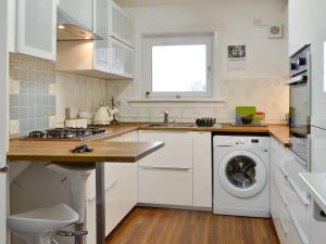 a white kitchen with a washer and dryer at Queens Buildings in Tayport
