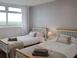 a bedroom with two beds and a window at Cotters Cottage - Uk10922 in Whithorn