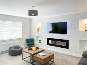a living room with a fireplace and a tv at 2 Mote View- Uk37496 in Sandhead