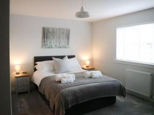 a bedroom with a bed with two towels on it at 2 Mote View- Uk37496 in Sandhead