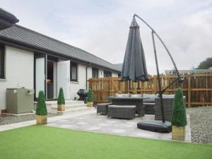 an outdoor patio with an umbrella and chairs and sidx sidx sidx at 2 Mote View- Uk37496 in Sandhead