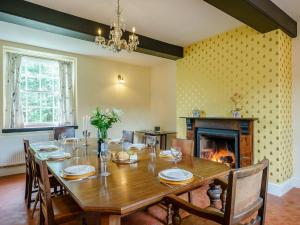 a dining room with a table and a fireplace at Malt House in Skenfrith