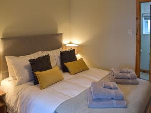 a bedroom with a large white bed with towels on it at Little Ingas Cottage in Strathmiglo