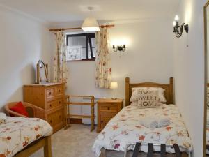 a bedroom with a bed and a dresser and a mirror at Gulls Nest in Morston