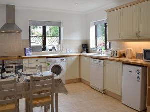 a kitchen with a washing machine and a dishwasher at Gulls Nest in Morston