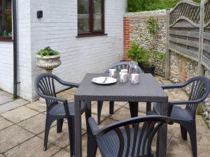 a black table and chairs on a patio at Gulls Nest in Morston