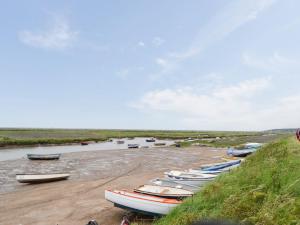 a group of boats are lined up on a beach at Gulls Nest in Morston