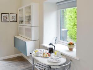 a white kitchen with a table and a window at The Studio At Westfield in Bellingham