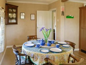 a table with blue and white plates and flowers on it at The Mews in Ellington