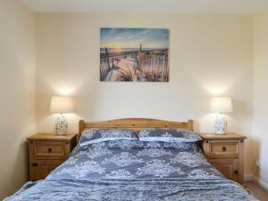 - une chambre avec un lit doté d'un couvre-lit bleu et de 2 lampes dans l'établissement High Tide, à Osborne