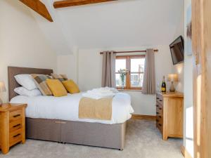 a bedroom with a bed and a tv and a window at The Old Laundry - Uk12136 in Hewelsfield