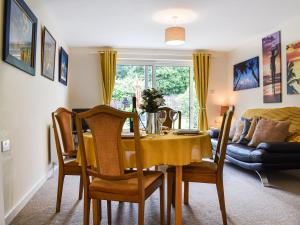 a dining room with a yellow table and chairs at Between The Forest And The Sea in New Milton