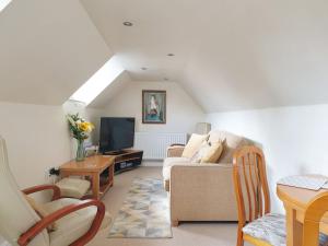 a living room with a couch and a tv at Chesterton Cottage in Miningsby