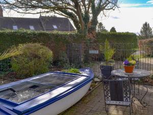 a blue and white boat sitting next to a table at Chesterton Cottage in Miningsby