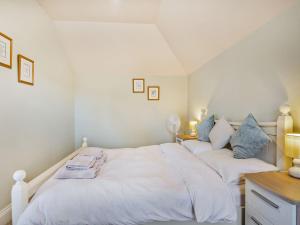 1 dormitorio con 2 camas con sábanas blancas y almohadas azules en The Potting Shed - Uk36120 en Horsington
