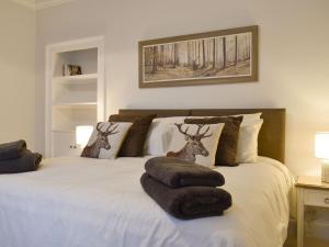 Un dormitorio con una cama con dos cabezas de ciervo. en West Lodge, en Banchory
