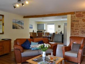a living room with a couch and chairs and a table at The Brewers Cottage in Mauchline