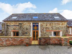 een oud stenen huis met een voordeur bij The Threshing Barn - Uk35754 in Bideford
