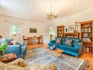 a living room with blue couches and a table at Quarry Lodge in Boughton Monchelsea