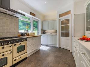 een keuken met witte kasten en een fornuis bij Quarry Lodge in Boughton Monchelsea
