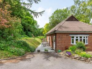 a brick cottage with a table and chairs in a garden at Quarry Lodge in Boughton Monchelsea