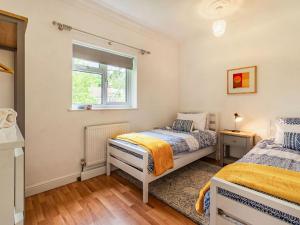 een slaapkamer met 2 bedden en een raam bij Quarry Lodge in Boughton Monchelsea