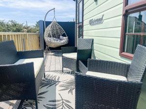 a patio with chairs and a hammock on a house at Sunnyside Lodge in Monreith
