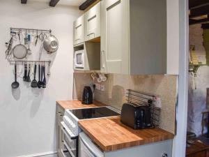 a kitchen with white cabinets and a counter top at Bwth Carron in Barmouth