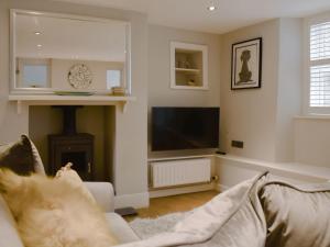 sala de estar con sofá y TV de pantalla plana en Treadle Cottage en Kirkby Lonsdale