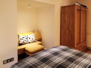 a bedroom with a bed and a bench and a cabinet at Kilbowie Retreat in Oban