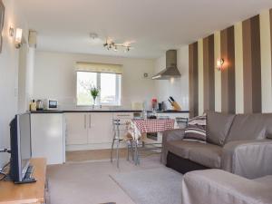 a living room with a couch and a kitchen at Mallard Cottage - Uk33872 in Cote