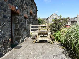 a group of picnic tables sitting next to a building at Stable Cottage - Uk12088 in Saint Endellion