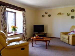 a living room with a couch and a coffee table at Stable Cottage - Uk12088 in Saint Endellion