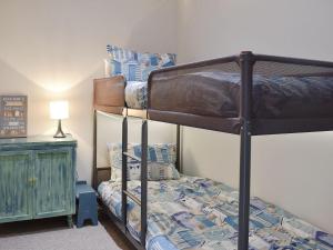 a bedroom with two bunk beds and a lamp at Serendipity in Ferndown
