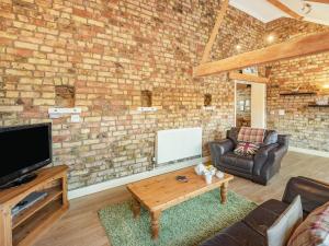 a living room with a brick wall at The Tack Rooms - Uk37520 in Routh