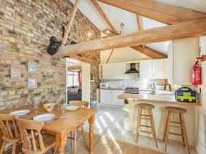 a kitchen and dining room with a wooden table and chairs at The Tack Rooms - Uk37520 in Routh