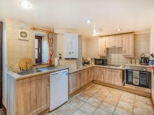 a large kitchen with wooden cabinets and a sink at The Barn in Poulton le Fylde