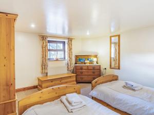 a bedroom with two beds and a dresser at The Barn in Poulton le Fylde