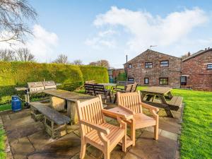 a patio with picnic tables and benches and a building at The Barn in Poulton le Fylde
