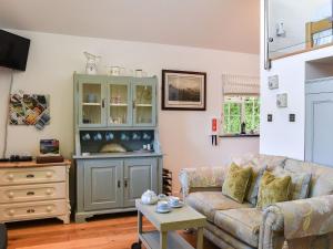 a living room with a couch and a cabinet at Woodland Retreat in Washaway