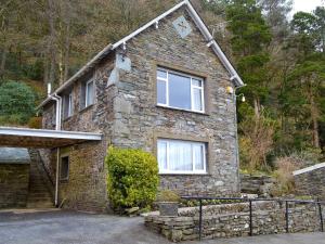 a stone house with a fence in front of it at The Coach House - Uk30813 in Braithwaite