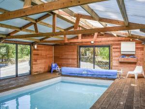 a swimming pool in a house with a wooden ceiling at Woodland Retreat in Washaway