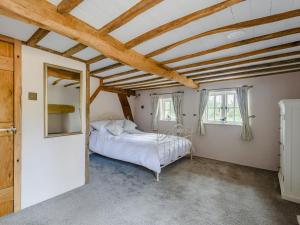 a bedroom with a bed and a wooden ceiling at The Restored Cottage in Eccleston