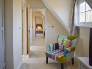 a hallway with a chair and a bedroom at Puxton Lodge in Fordwich