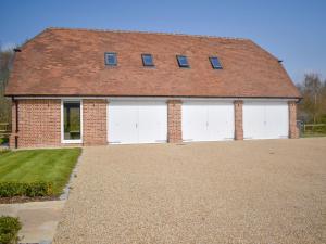 a brick house with two white garage doors at Puxton Lodge in Fordwich