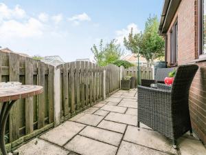 a patio with a table and chairs and a fence at Berwood Cottage in Epworth