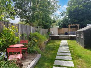 a garden with a table and chairs and a fence at Driftwood House in Sheringham